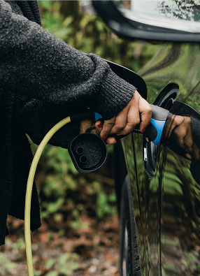 Persona cargando vehículo eléctrico